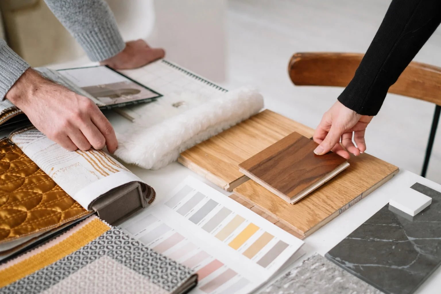 Hands selecting building material samples for export sourcing and product selection